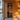 Modern wooden sauna interior with a glass sauna door, black hinges, warm LED lighting, benches, and forest lake view