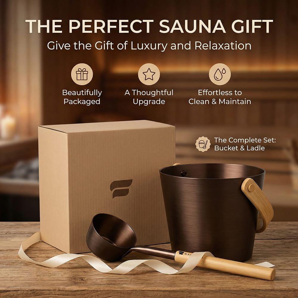 A sauna gift set featuring a dark bronze bucket with a light wood handle, a matching ladle with a wooden handle, and a brown kraft gift box, arranged on a wooden surface with promotional text in a warm indoor setting.