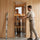 Installer checking the fit and swing of a clear glass sauna door with an alder frame