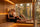 A woman with her long hair tucked under a cream wool sauna hat and a man in a grey wool beanie relaxing in a warm cedar sauna.