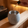 Essential oil drops being added with a glass pipette into a soapstone aromatherapy cup filled with water inside a warm wooden sauna