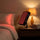 SAUNOM red light therapy panel on bedside table during an evening red light session
