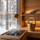 Gold SAUNOM ladle pouring water onto sauna stones with steam rising beside a matching water bucket
