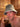 Man relaxing inside a wooden sauna while wearing a grey wool sauna hat