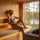 Man wearing a grey wool sauna hat while relaxing in a lakeside sauna