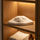 White merino wool sauna hat displayed flat on a wooden shelf with towels and amber bottle