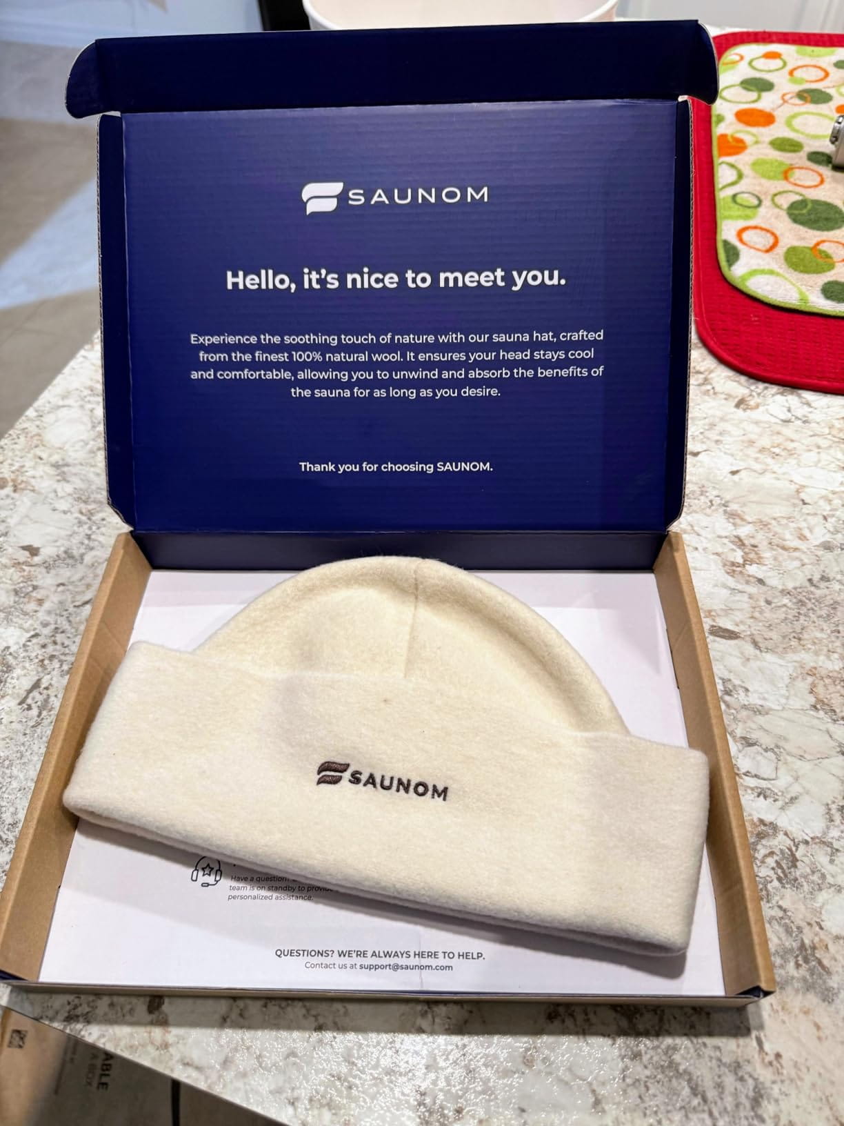 White wool sauna hat displayed inside an open branded gift box