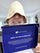 Man wearing a white wool sauna hat while holding SAUNOM product packaging