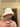 Man taking a mirror selfie while wearing a white bucket-style sauna hat
