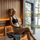 Woman resting after a workout in a modern sauna with towel, water bottle, and lake view