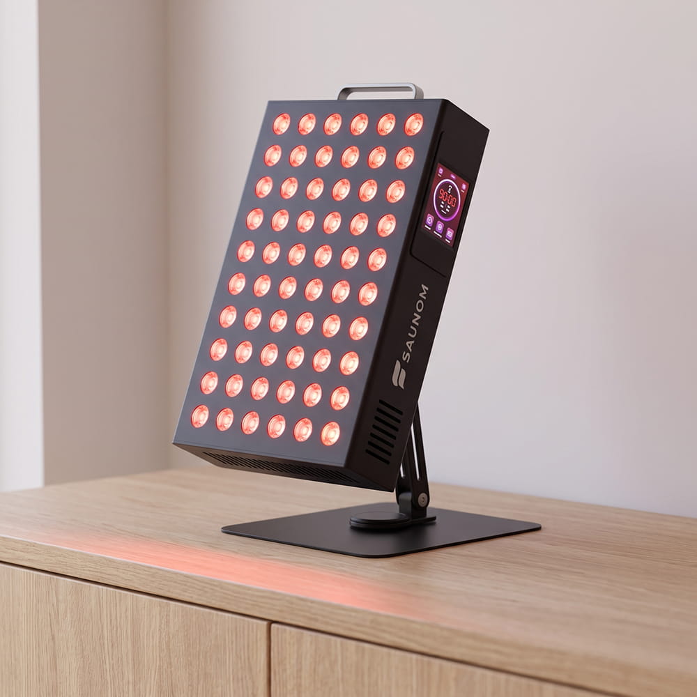 Saunom EW300 Pro red light therapy panel tilted back on its weighted tabletop stand with swivel base