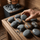 Old cracked sauna stones being inspected and replaced on a wooden sauna bench