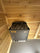 Rounded sauna stones placed on top of an electric sauna heater inside a wooden sauna