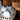 Rounded sauna stones stacked inside a sauna heater with branded packaging in the background