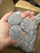 Rounded gray sauna stones held in hand before being placed in a sauna heater
