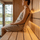 Close side view of a woman supported by a curved SAUNOM wooden sauna backrest
