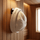 White wool beanie-style sauna hat hanging on a wall hook inside a wooden sauna