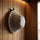 Grey wool bucket-style sauna hat hanging on a wall hook inside a wooden sauna