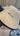 Close-up of a white wool sauna hat with embroidered SAUNOM logo and stitched edge