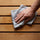 Finishing a sauna bench with a damp cloth after cleaning
