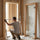 Installer measuring the rough opening for a 27 by 74⅜-inch clear glass sauna door