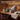 Gift-themed sauna product graphic showing a grey SAUNOM wool sauna hat with wrapped gift, towel, eucalyptus, and sauna accessories