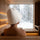 Close-up from behind of a white sauna hat worn inside a sauna with snowy forest view
