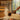 Brown aluminum sauna ladle pouring water over hot sauna stones to make loyly steam