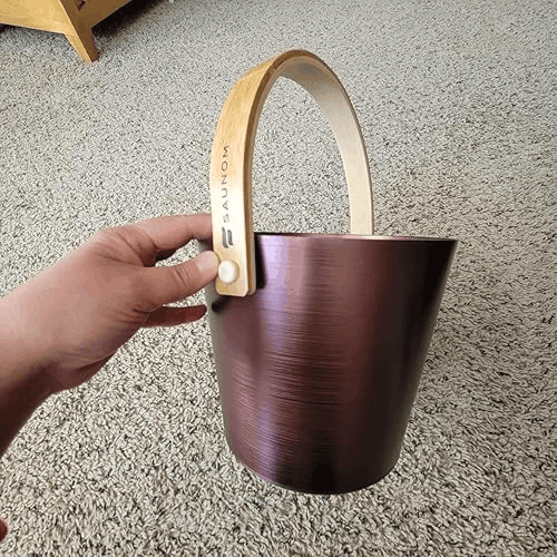 Dark anodized sauna bucket with wooden handle and SAUNOM logo