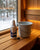Saunom sauna cleaner bottle beside a plastic bucket of warm water, diluted concentrate ready to use