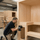 Craftsman assembling a wooden SAUNOM sauna room in a professional workshop, showing careful construction and build quality
