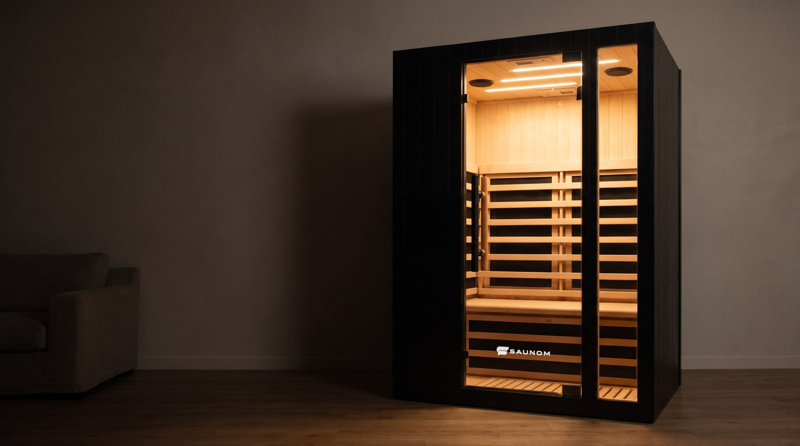Black Saunom 2-person infrared sauna glowing warm in a dark living room