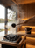 Close-up of water pouring from a SAUNOM sauna ladle onto steaming hot stones inside a wood-lined sauna