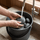 Rounded sauna stones being rinsed under running water before use