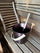 Dark sauna bucket with wooden handle and matching ladle on a wooden sauna bench