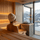 Woman wearing a white sauna hat while relaxing in a modern sauna with snowy mountain view