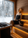 Woman relaxing between löyly pours beside a SAUNOM sauna bucket and steaming heater stones