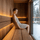 Woman sitting in a sauna without back support, looking uncomfortable